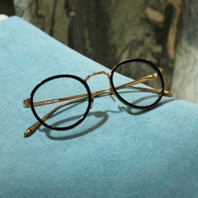 Acetate and gold glasses on blue background.