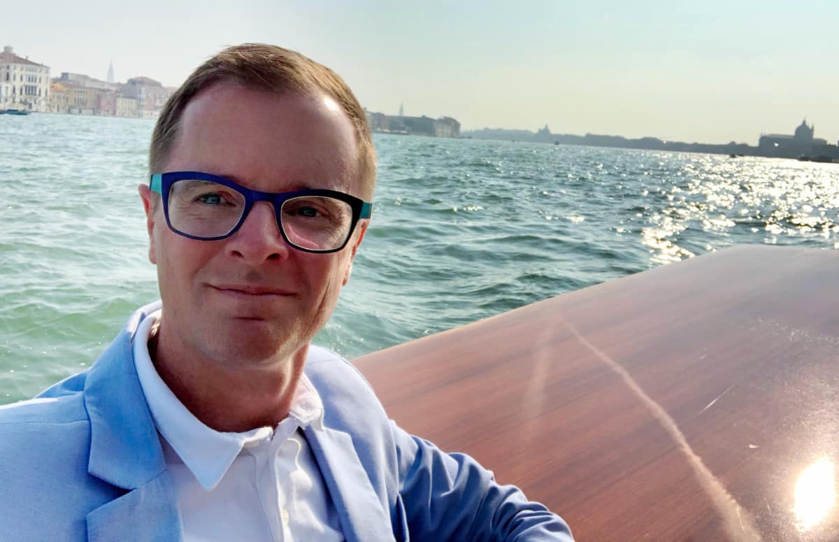 Jason Kerr on a boat in Venice, Italy. He wears glasses, but can switch to scleral contact lenses.