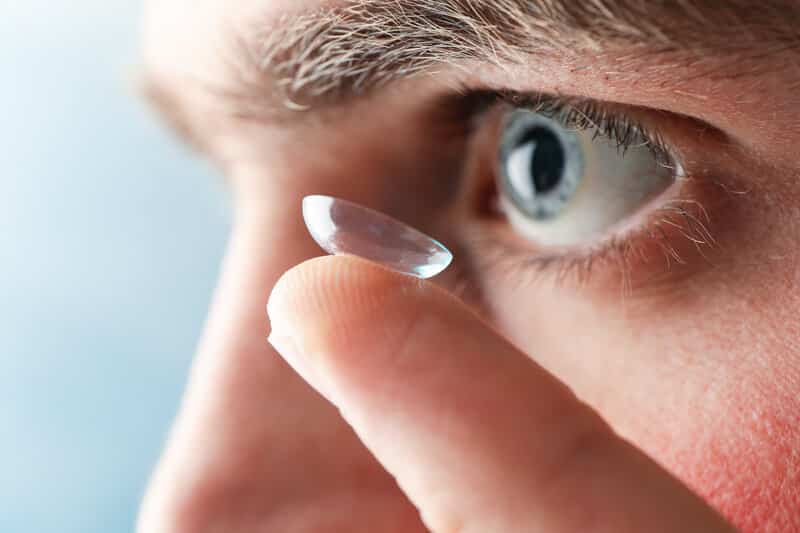 man inserting contact lens