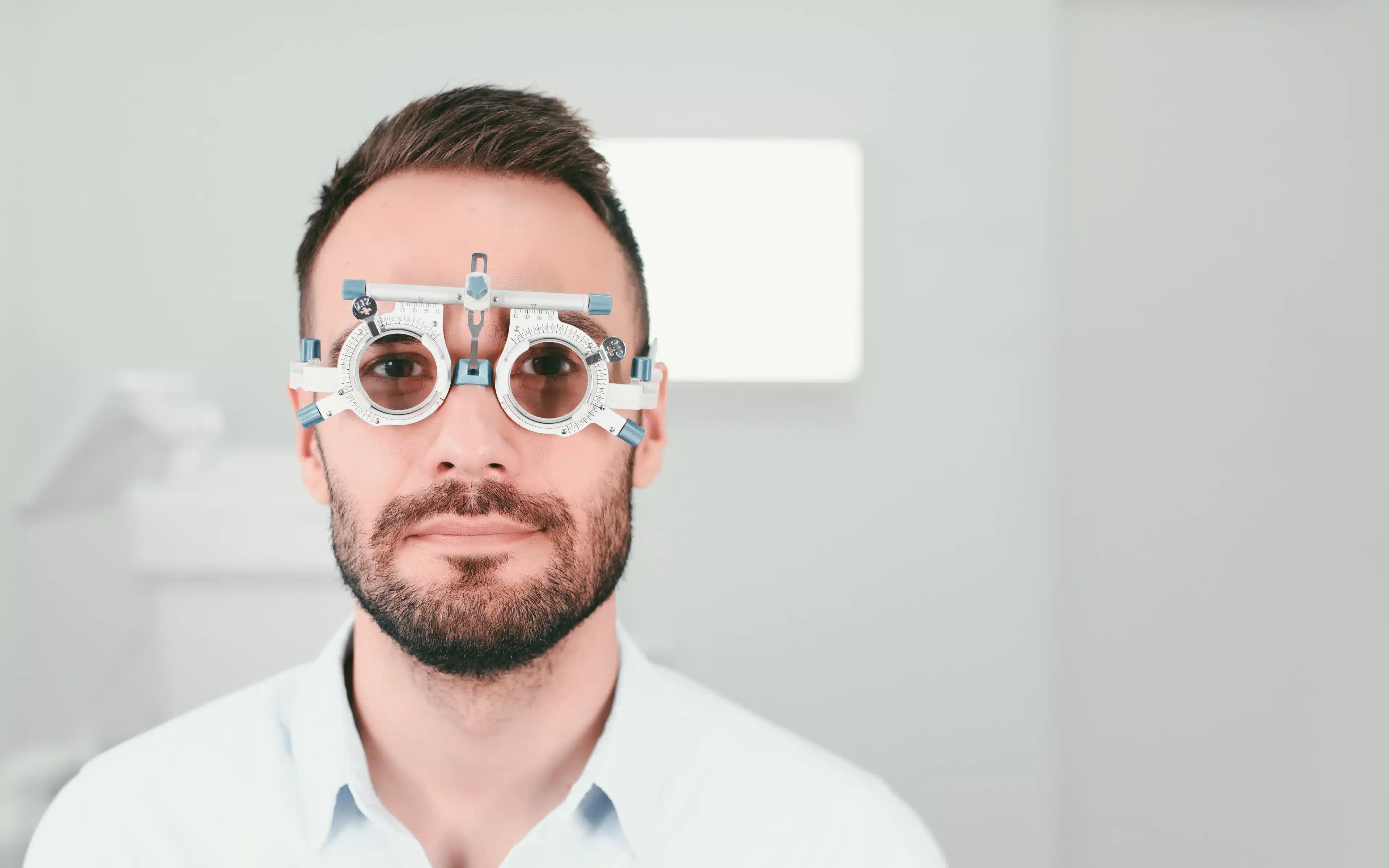 A handsome man having an eye test.