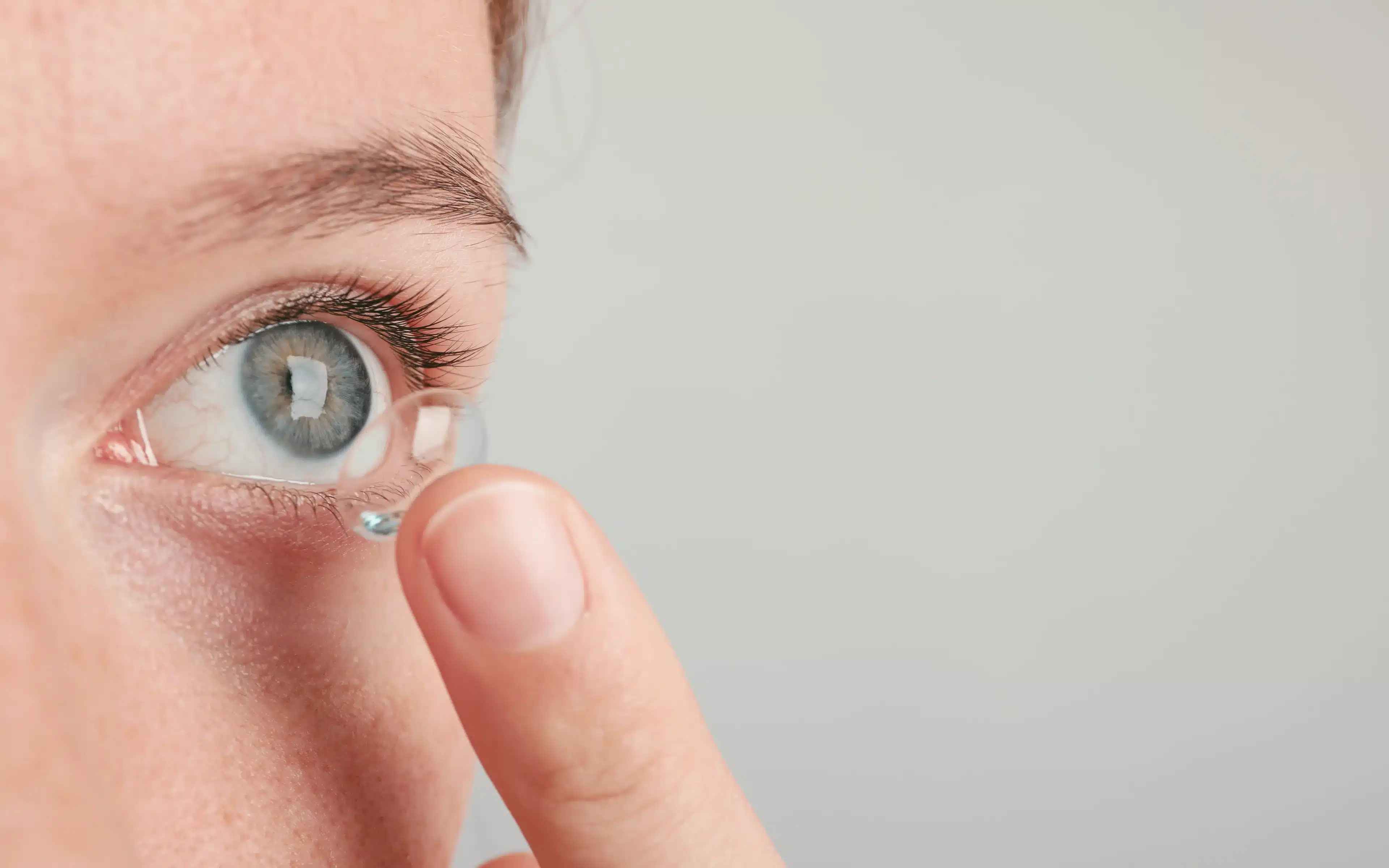 Close up portrait of a male inserting a contact lens.