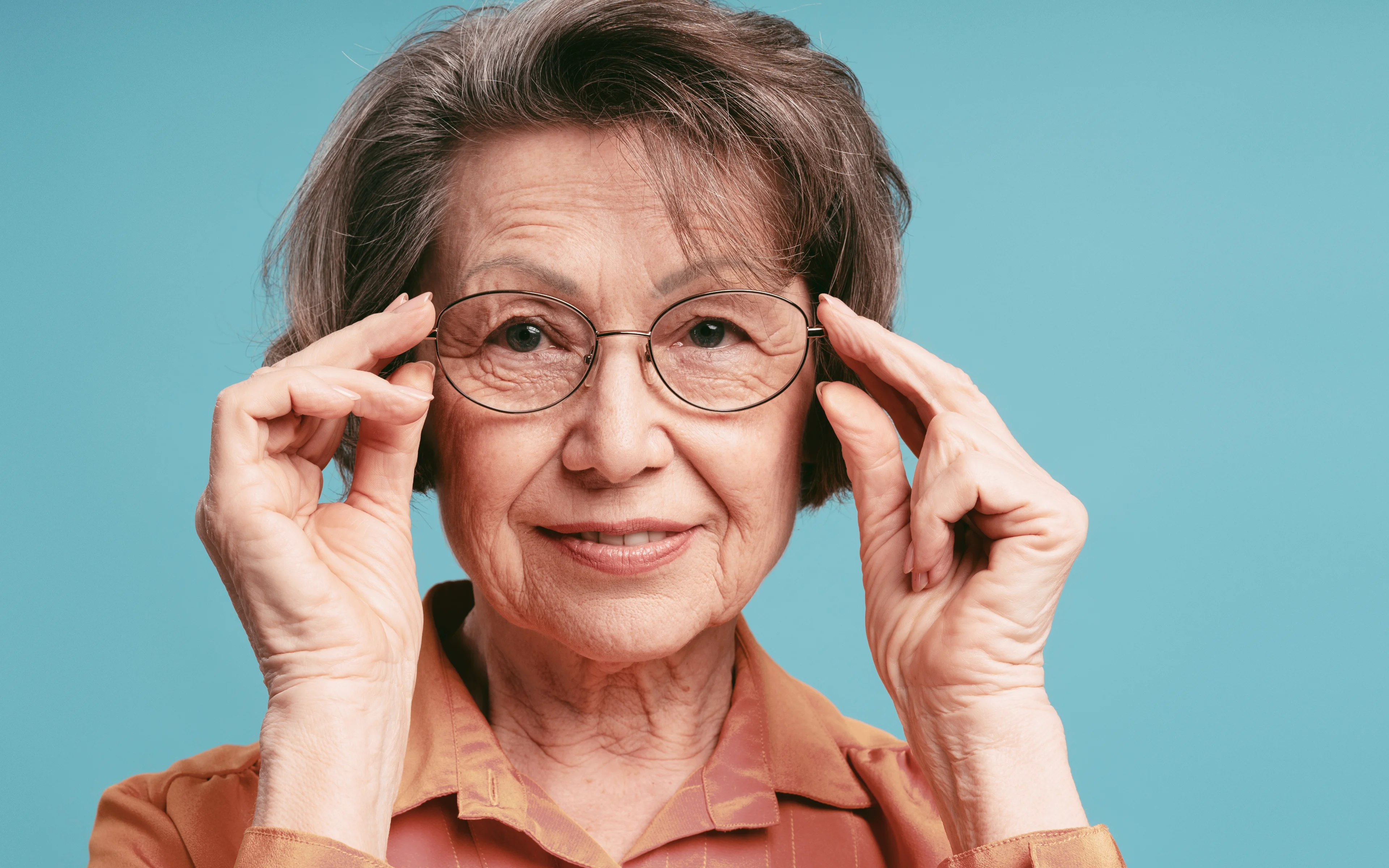 A middle aged female wearing glasses.