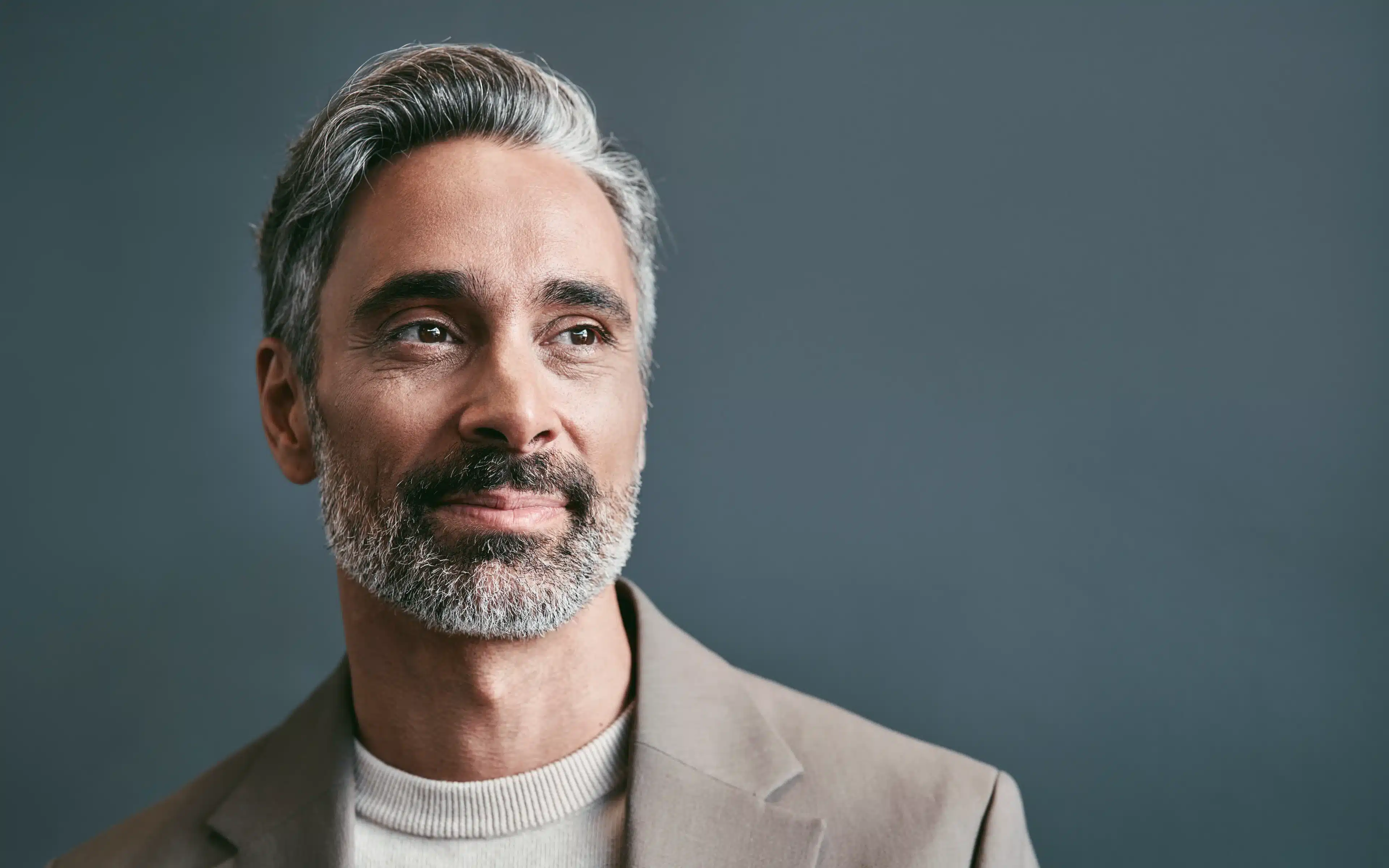 Middle aged business man wears hard contact lenses and looks away.