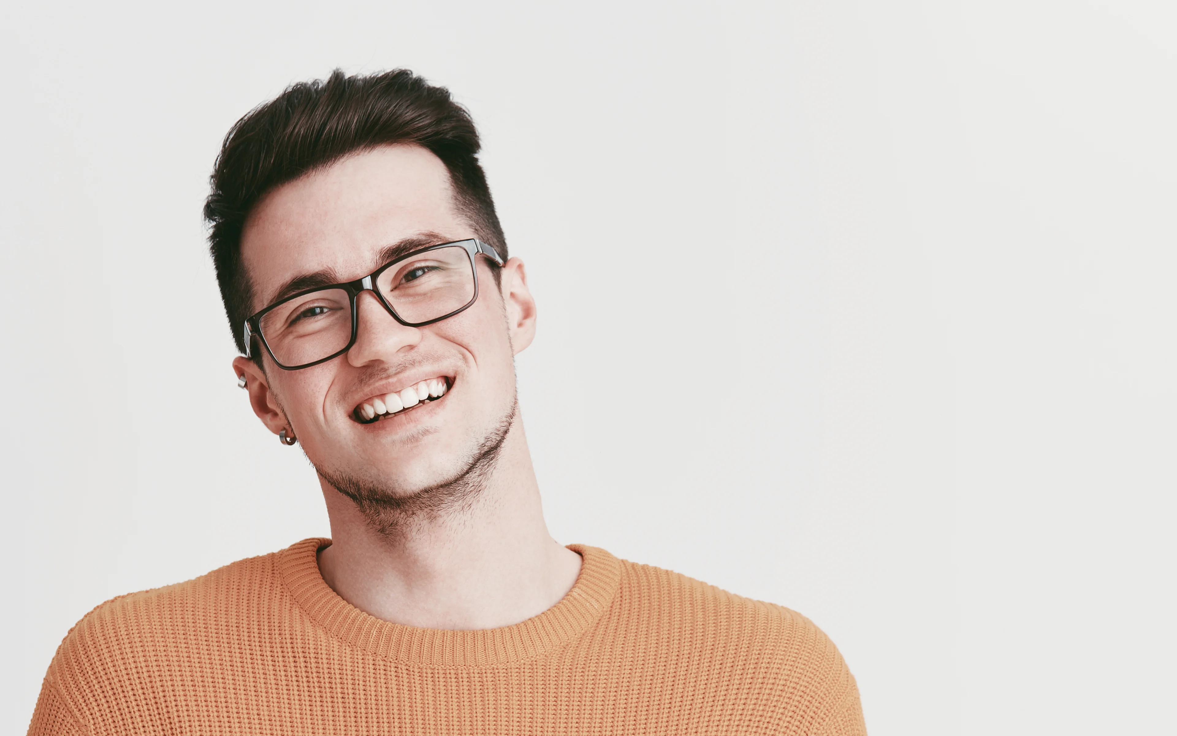 A young, happy male wearing glasses.