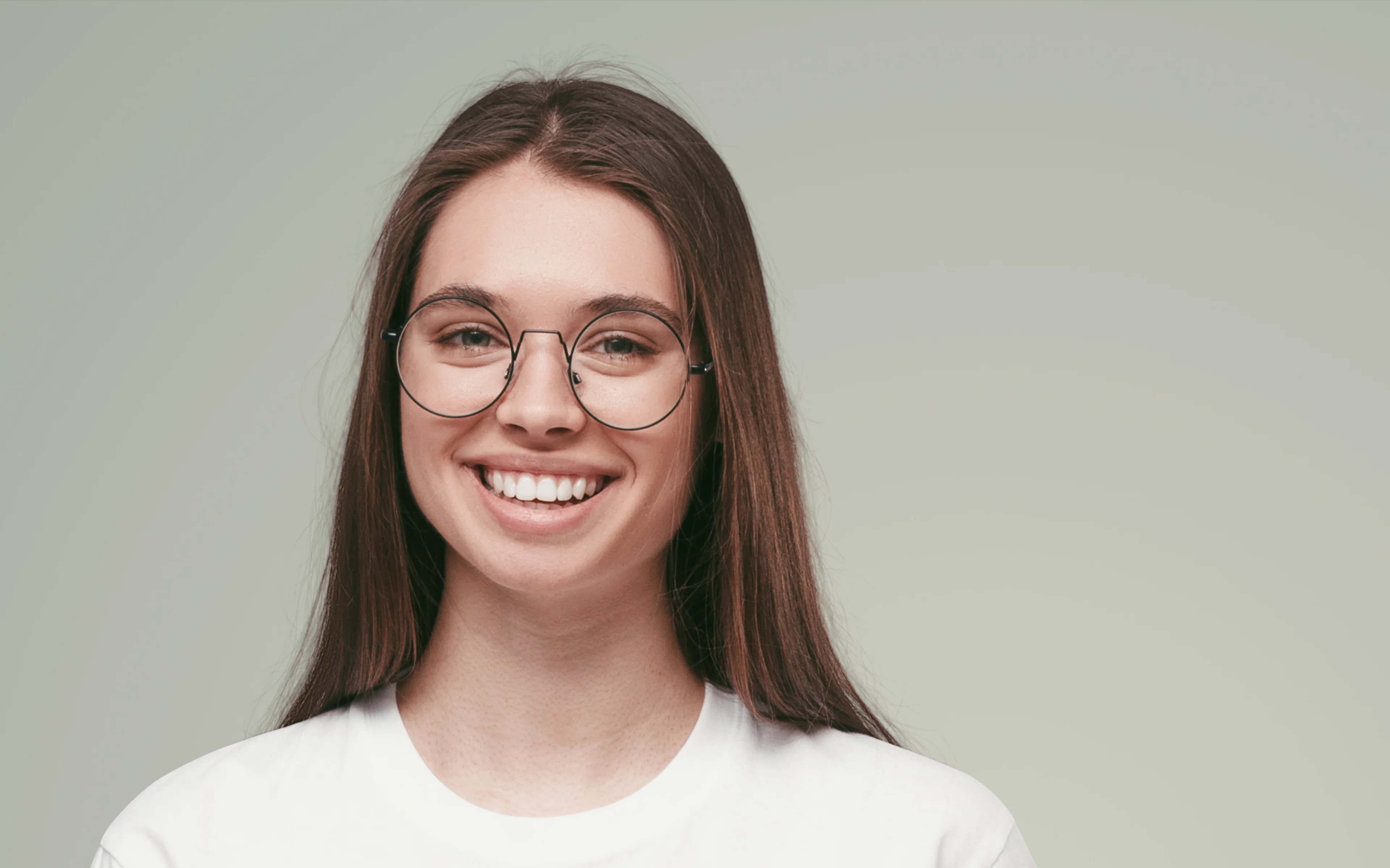 A young female smiling and wearing spectacles.