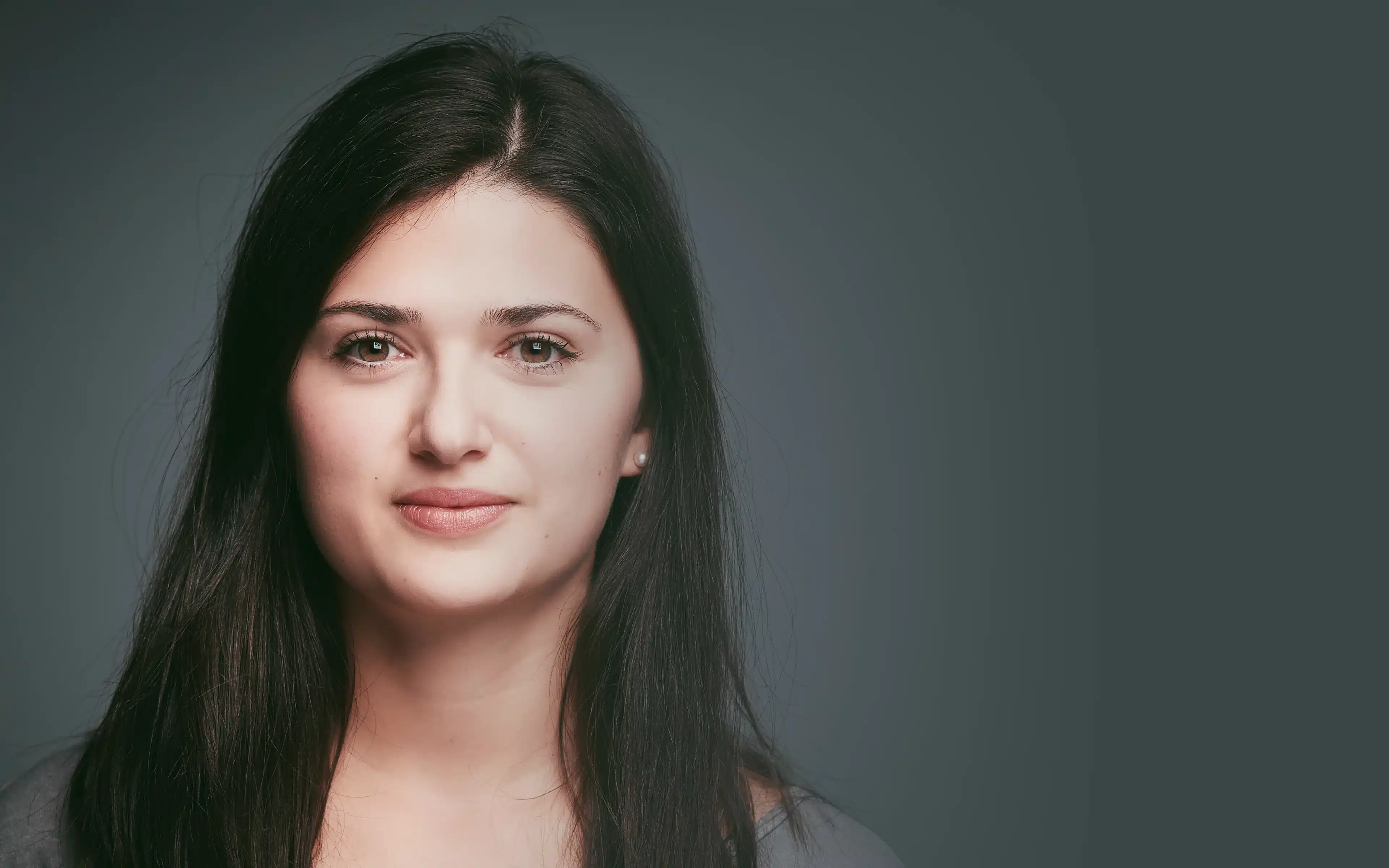 Portrait of smiling brunette woman wearing contact lenses.