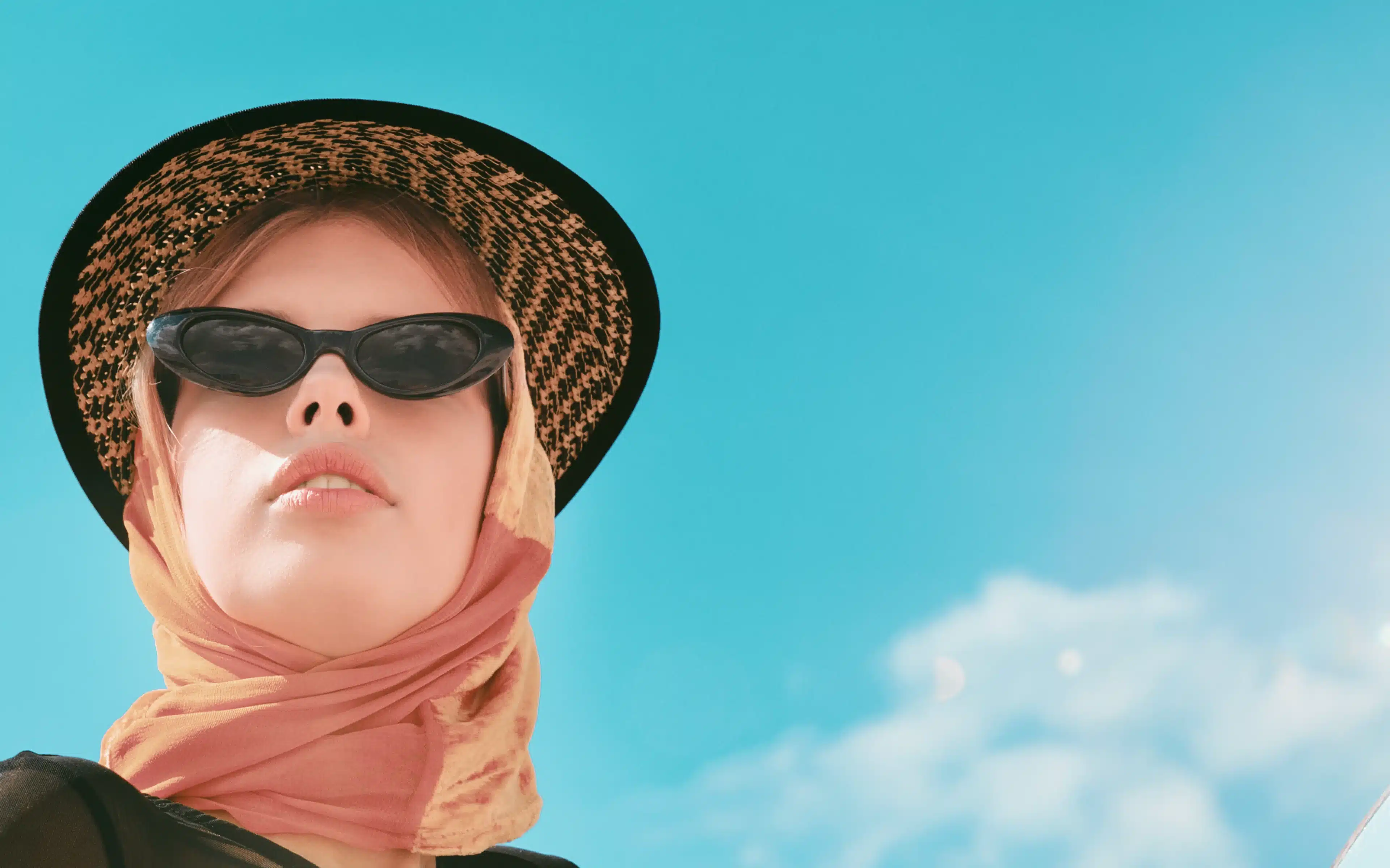 A stylish beautiful woman posing while wearing sunglasses to protect her eyes from sunflare.