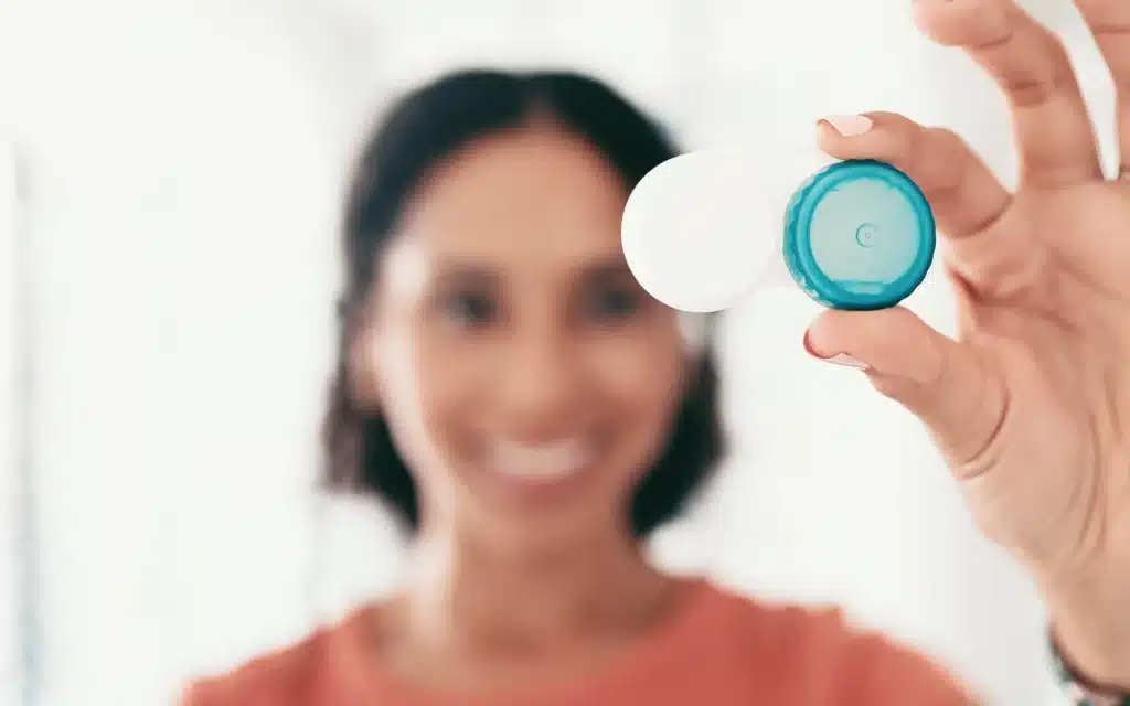 Smiling woman holding open scleral contact lens storage case