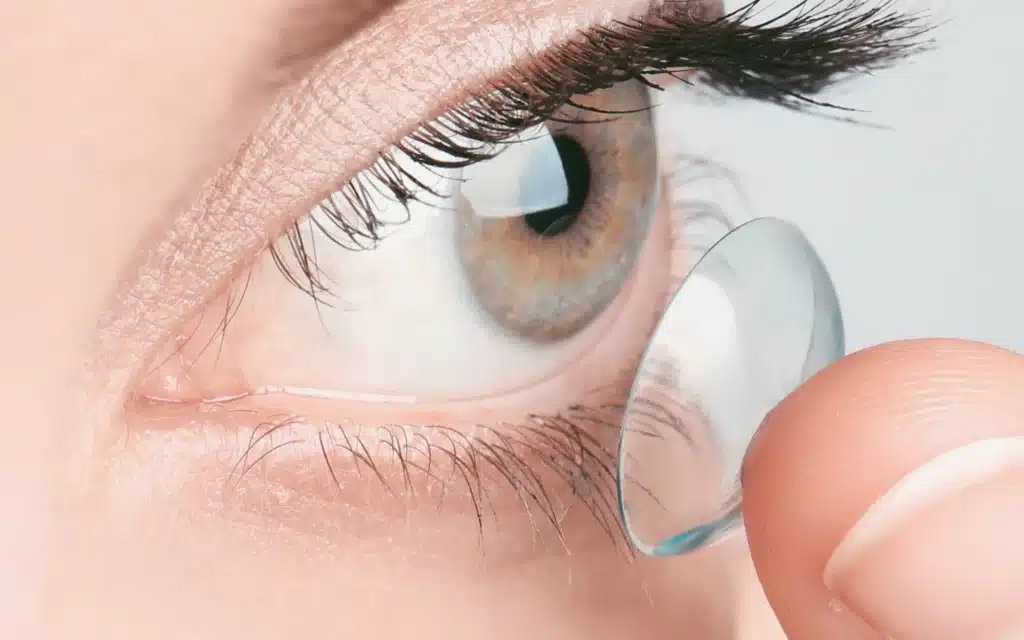 Close-up of scleral contact lens being inserted into a hazel eye